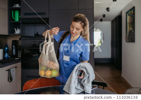Female nurse returning home from work with groceries for family. Work-life balance of healthcare worker as parent and partner. Female nurse returning home from work with groceries for family. Work-life balance of healthcare worker as parent and partner. 111036138