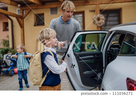 Children getting into the car, father taking them to school and kindergarten before going to work. 111036271