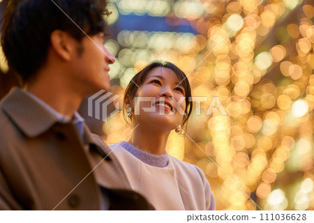 A woman happily talking to a man in an illuminated cityscape 111036628