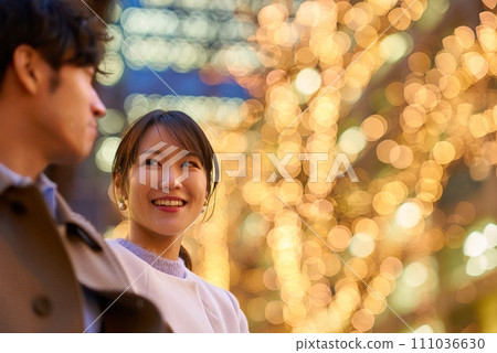一位女士在燈光明亮的城市景觀中愉快地與一位男士交談 一位女士在燈光明亮的城市景觀中愉快地與一位男士交談 111036630
