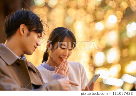 一個女人和一個男人愉快地操作智慧型手機 111037428
