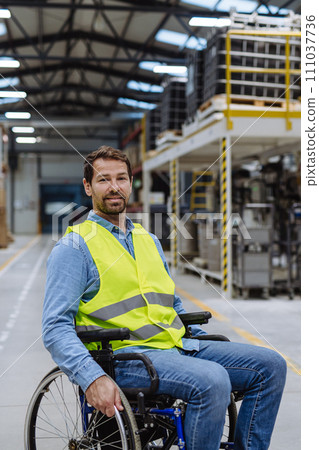 Portrait of man in wheelchair working in modern industrial factory. Concept of workers with disabilities, accessible workplace for employees with mobility impairment. Portrait of man in wheelchair working in modern industrial factory. Concept of workers with disabilities, accessible workplace for employees with mobility impairment. 111037736