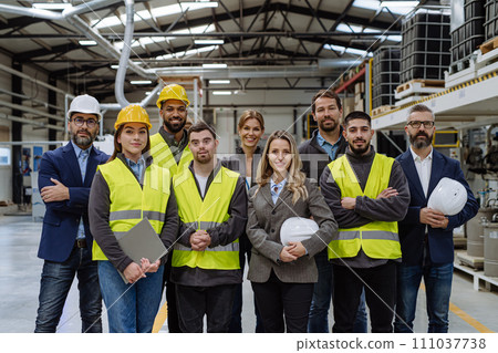 Full team of warehouse employees standing in warehouse. Team of workers, managers, female director and worker with down syndrome in modern industrial factory, heavy industry, manufactrury. Full team of warehouse employees standing in warehouse. Team of workers, managers, female director and worker with down syndrome in modern industrial factory, heavy industry, manufactrury. 111037738