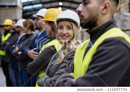 Full team of warehouse employees standing in warehouse. Team of workers in reflective clothing in modern industrial factory, heavy industry, manufactrury. Full team of warehouse employees standing in warehouse. Team of workers in reflective clothing in modern industrial factory, heavy industry, manufactrury. 111037739