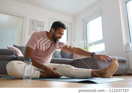 Woman exercising at home, stretching her body. Solo home workout and meditation, morning or evening workout routine. 111037787