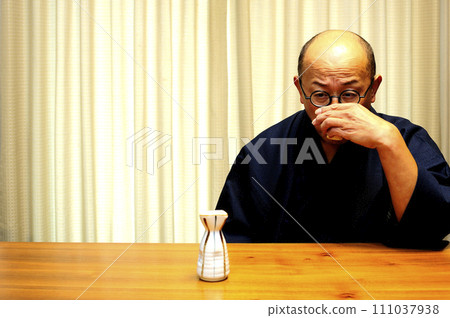 A man who enjoys drinking in a kimono A man who enjoys drinking in a kimono 111037938