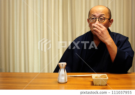 A man who enjoys drinking in a kimono A man who enjoys drinking in a kimono 111037955