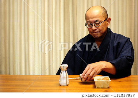 A man who enjoys drinking in a kimono A man who enjoys drinking in a kimono 111037957