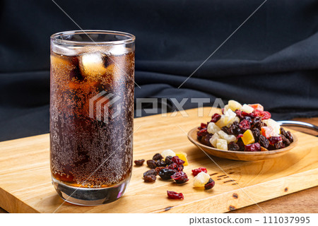 Closeup of cold cola water with ice cubes in transparent glass. Closeup of cold cola water with ice cubes in transparent glass. 111037995