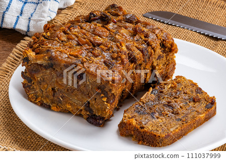 Slice of delicious homemade fruitcake in white ceramic plate. Slice of delicious homemade fruitcake in white ceramic plate. 111037999