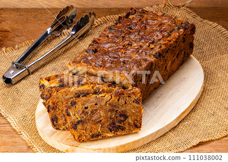 Slice of delicious homemade fruitcake on wooden board. Slice of delicious homemade fruitcake on wooden board. 111038002
