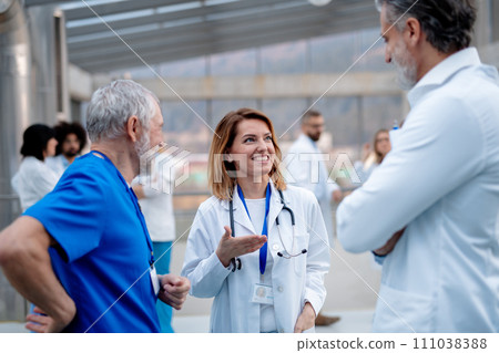 Group of doctors talking during conference. Medical networking. Medical experts attending an education event, seminar in board room. Age and gender equity in healthcare. 111038388