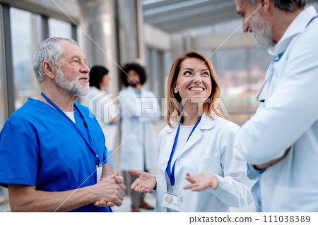 Group of doctors talking during conference. Medical networking. Medical experts attending an education event, seminar in board room. Age and gender equity in healthcare. 111038389