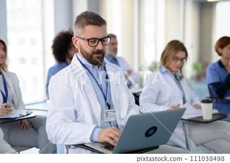 Group of doctors on conference, medical team sitting and listening speaker. Medical experts attending an education event, seminar in board room. 111038498