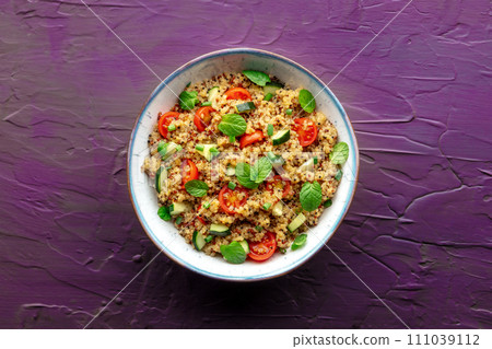 Quinoa tabbouleh salad in a bowl, a healthy dinner with tomatoes and mint 111039112
