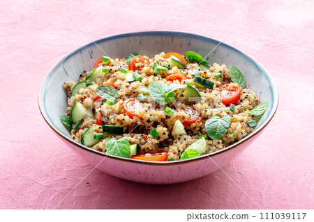 Quinoa tabbouleh salad in a bowl, a healthy dinner with tomatoes and mint Quinoa tabbouleh salad in a bowl, a healthy dinner with tomatoes and mint 111039117