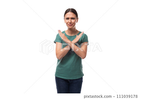 young beautiful brunette lady dressed in a green t-shirt and jeans crossed her arms in disagreement young beautiful brunette lady dressed in a green t-shirt and jeans crossed her arms in disagreement 111039178