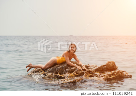 Woman travel sea. Happy tourist in hat enjoy taking picture outdoors for memories. Woman traveler posing on the beach at sea surrounded by volcanic mountains, sharing travel adventure journey 111039241
