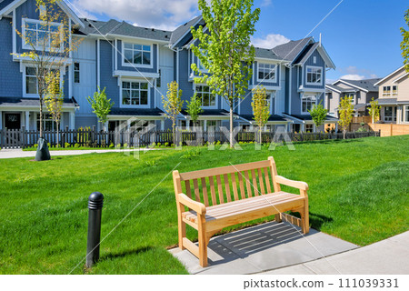 Bright wooden bench in a small recreational park 111039331