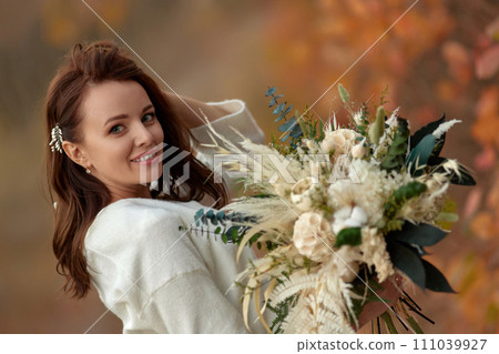 portrait of beautiful happy bride holding wedding autumn bouquet in nature portrait of beautiful happy bride holding wedding autumn bouquet in nature 111039927