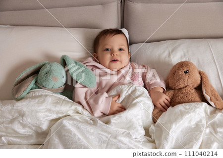 cute little child with fluffy toy bunny in white bed cute little child with fluffy toy bunny in white bed 111040214