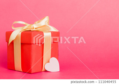 gift box with red bow and red heart on colored background. Perspective view. Flat lay 111040455