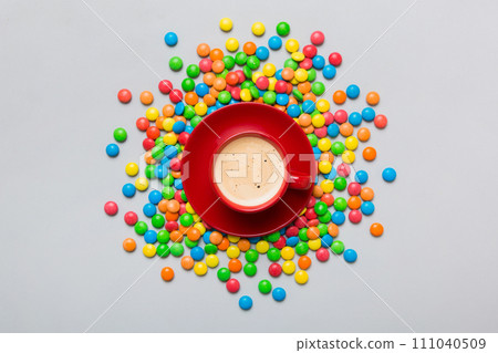 Coffee cup with chocolates and colored candy. Top view on table background with copy space 111040509