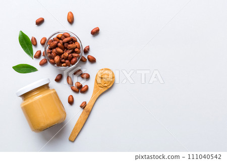 Bowl of peanut butter and peanuts on table background. top view with copy space. Creamy peanut pasta in small bowl Bowl of peanut butter and peanuts on table background. top view with copy space. Creamy peanut pasta in small bowl 111040542