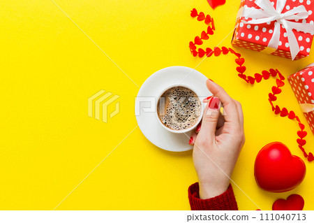 Flat lay of heart shaped cup of black coffee in the hands of women on colored background with copy space top view. Valentine day and holiday concept 111040713