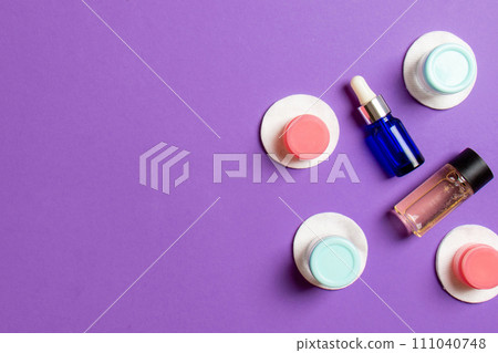 Set of travel size cosmetic bottles on colored background. Flat lay of cream jars. Top view of bodycare style concept 111040748