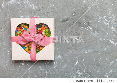 Box with sweet chocolate candies on color background, Various candy sweets. Valentines day gift box. Top view flat lay with copy space 111040838