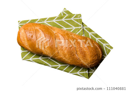 Freshly baked delicious french bread with napkin isolated on white background top view. Healthy white bread loaf 111040881