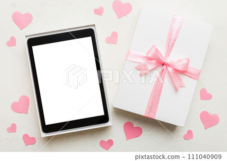 Gift box of open tablet for the holidays with a bow top view 111040909
