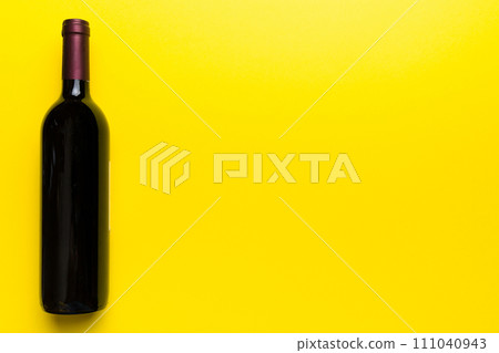 One Bottle of red wine on colored table. Flat lay, top view wth copy space 111040943