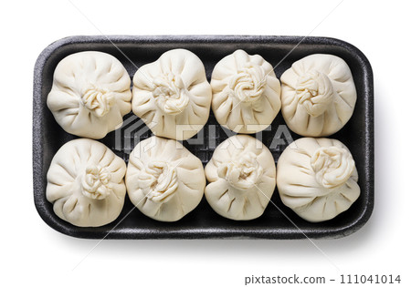 Raw khinkali in a plastic tray on a white background. Top view 111041014