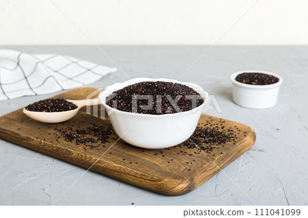 quinoa seeds in bowl and spoon on colored background. Healthy kinwa in small bowl. Healthy superfood 111041099