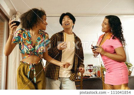 Group of young smiling friends having party and dancing at home. Friendship life style concept  111041854
