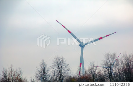 Wind turbine station windmill park next to the road in Austria in cloudy weather. Wind turbine station windmill park next to the road in Austria in cloudy weather. 111042256