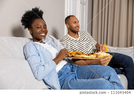 Happy beautiful man and eating popcorn and pizza watching movie woman Happy beautiful man and eating popcorn and pizza watching movie woman 111043404
