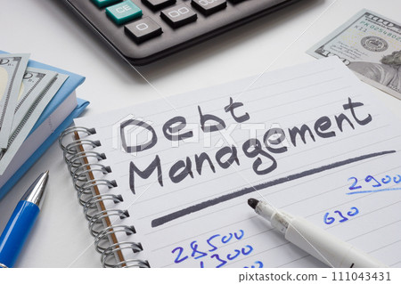Open notepad with calculations and inscription debt management. 111043431