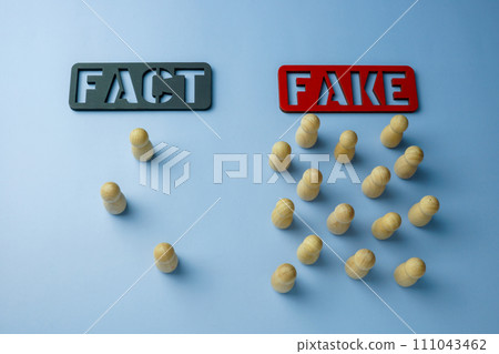 Plates of fact and fake with figures who chose them. Disinformation and propaganda concept. 111043462