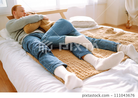 Couple in love relaxing at home on bed while they hug each other. Valentine's Day, holiday concept. 111043676