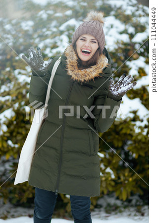 happy modern woman outdoors in city park in winter 111044449