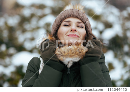 happy modern woman outdoors in city park in winter 111044450