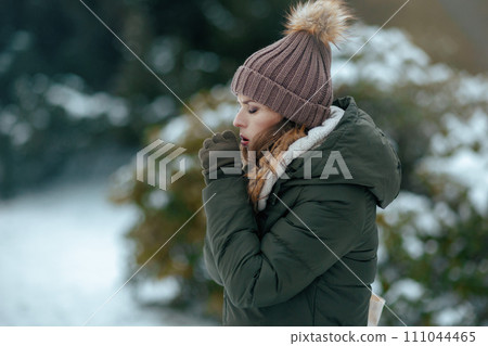 sad modern woman outdoors in city park in winter coughing sad modern woman outdoors in city park in winter coughing 111044465