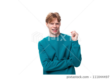young stylish guy with short red hair dressed in a blue pullover on a white background 111044497