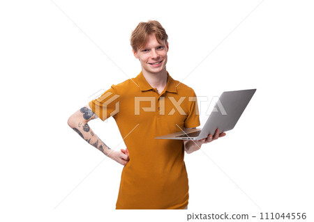 smart young red-haired caucasian male student with a tattoo dressed in a mustard t-shirt is holding smart young red-haired caucasian male student with a tattoo dressed in a mustard t-shirt is holding 111044556