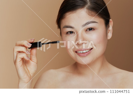 Portrait of young woman with mascara 111044751