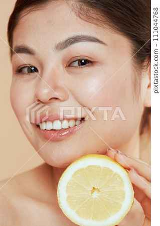 Portrait of modern asian female with lemon 111044768