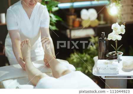 Closeup on medical massage therapist massaging clients leg 111044923